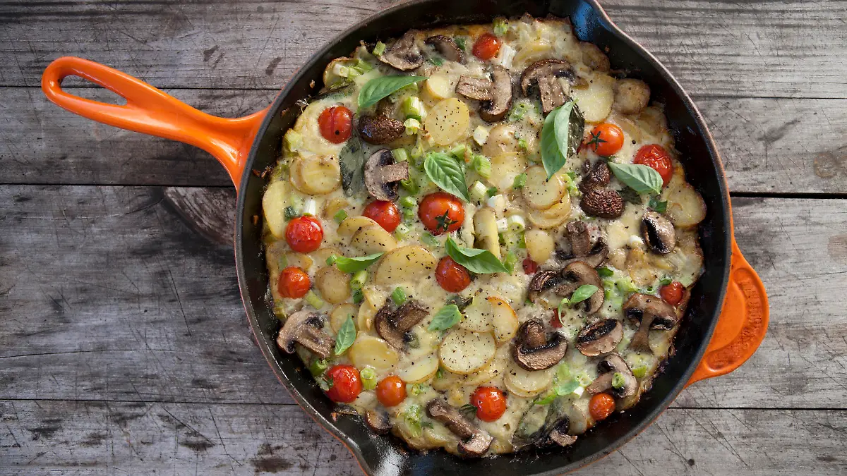 A delicious Spanish Omelette displayed on a wooden background.