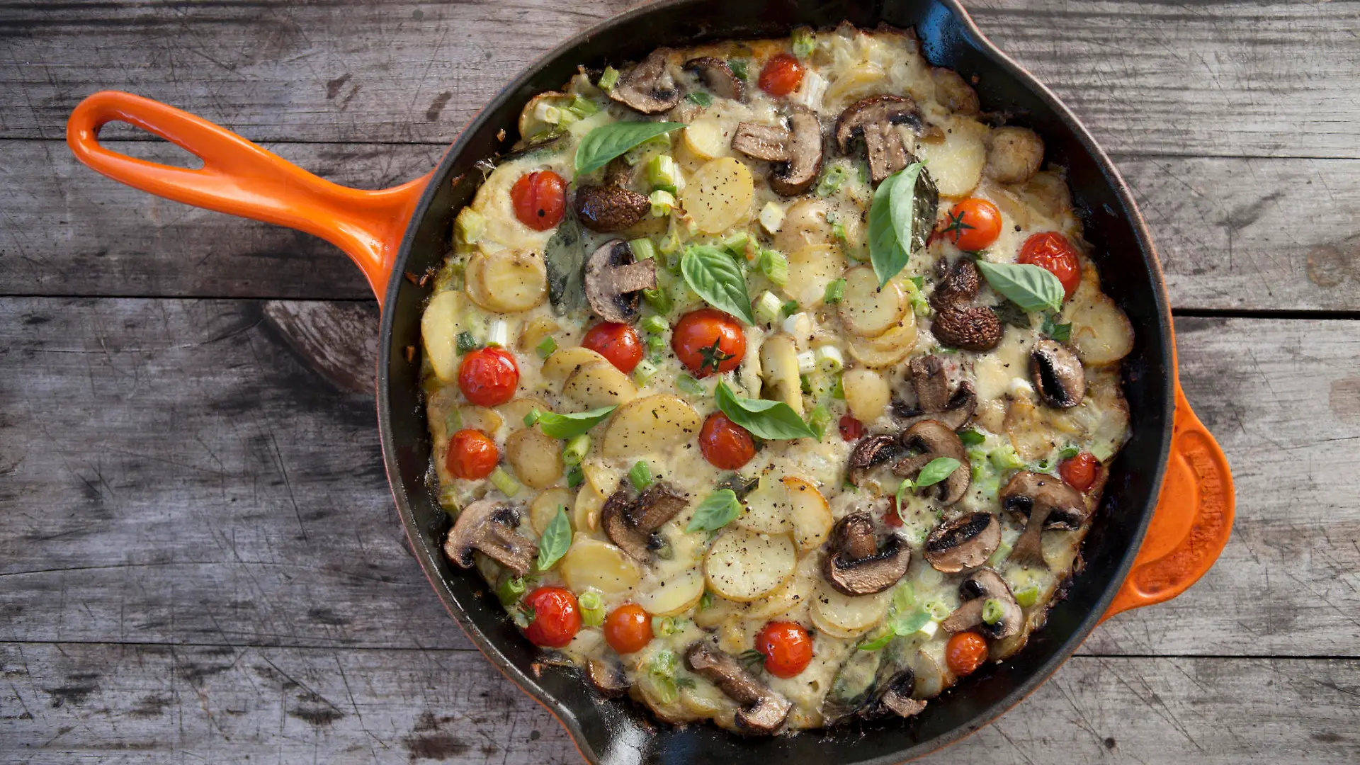A delicious Spanish Omelette displayed on a wooden background.