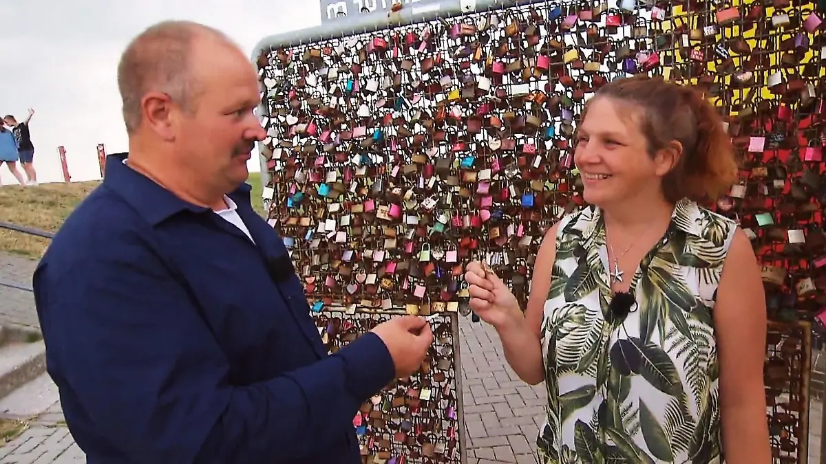 Bauer Burkhard und seine Tanja hängen ein Liebesschloss auf.