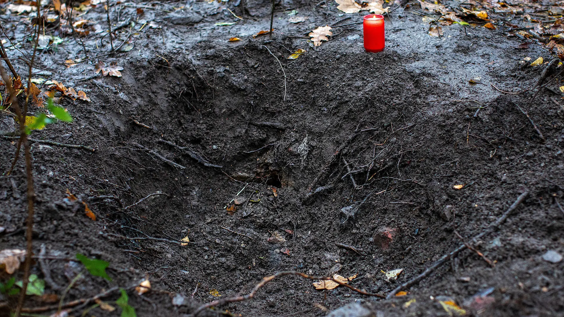 06.12.2019, Nordrhein-Westfalen, Duisburg: Ein Grablicht steht an einer Grube in einem Waldstück in Duisburg. Die Polizei hat in einem Wald in Duisburg die Leiche einer jungen Frau gefunden. Laut Staatsanwaltschaft gehen die Ermittler davon aus, dass es sich um eine seit drei Monaten vermisste 26-Jährige handelt. Der Ehemann (28) der Frau wurde vorläufig festgenommen. Er soll im Laufe des Tages einem Haftrichter vorgeführt werden. Foto: Christoph Reichwein/dpa +++ dpa-Bildfunk +++