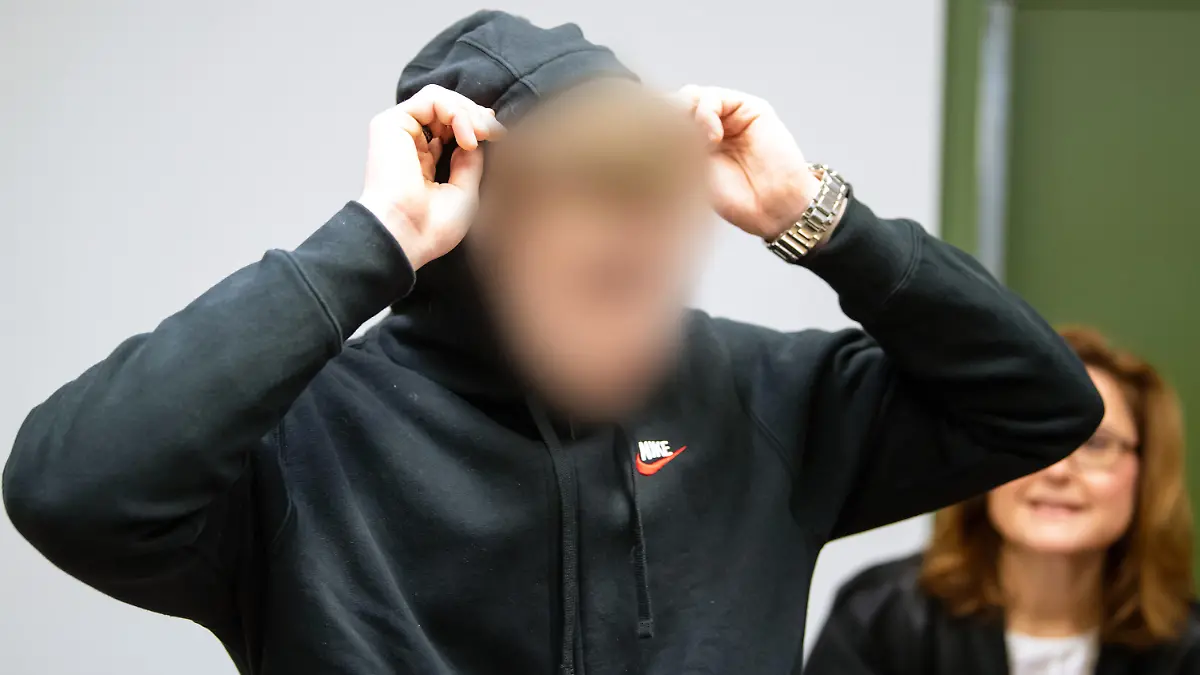 10.12.2019, Bayern, München: Der wegen Mordes und mehrfachen Mordversuchs angeklagte 21-Jährige steht vor Prozessbeginn im Sitzungssaal im Landgericht. Laut Anklage soll der Mann im Sommer 2018 die 25 Jahre alte Schwester seiner Ex-Freundin in der Wohnung der Familie mit einem Messer getötet haben. Auch die Mutter und den 15-jährigen Bruder soll er angegriffen haben. Foto: Sven Hoppe/dpa - ACHTUNG: Der Angeklagte wurde auf Wunsch seiner Anwältin gepixelt +++ dpa-Bildfunk +++