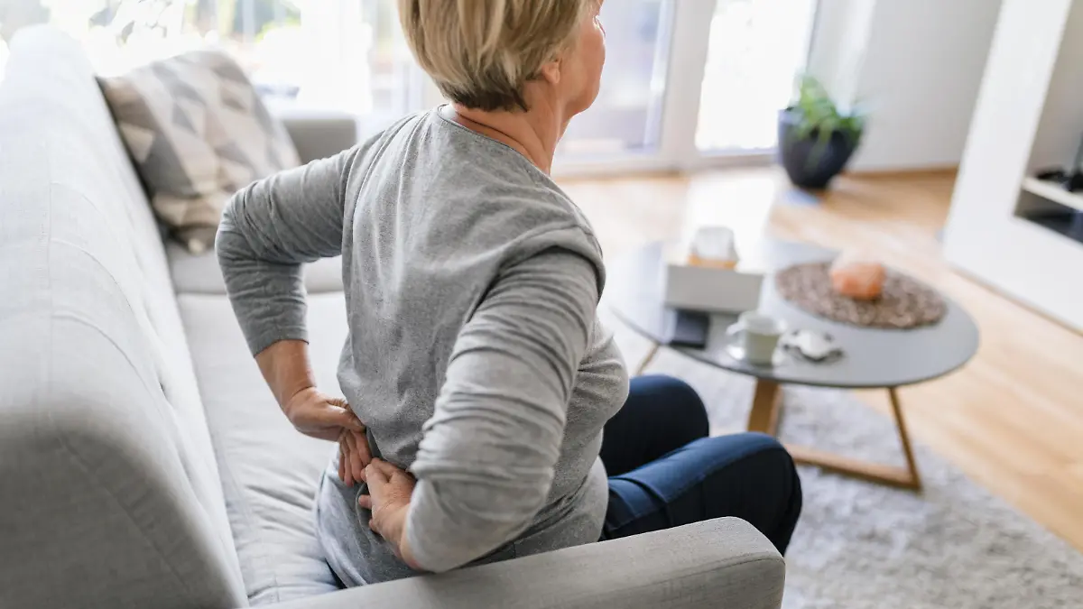 Elderly woman at home with lower back pain || Modellfreigabe vorhanden