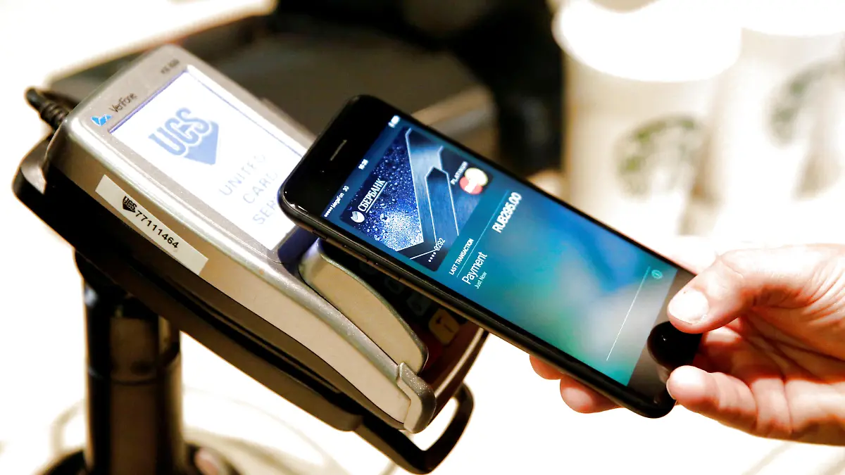 FILE PHOTO: A man uses an iPhone 7 smartphone to demonstrate the mobile payment service Apple Pay at a cafe in Moscow, Russia, October 3, 2016. Picture taken October 3, 2016. REUTERS/Maxim Zmeyev/File Photo