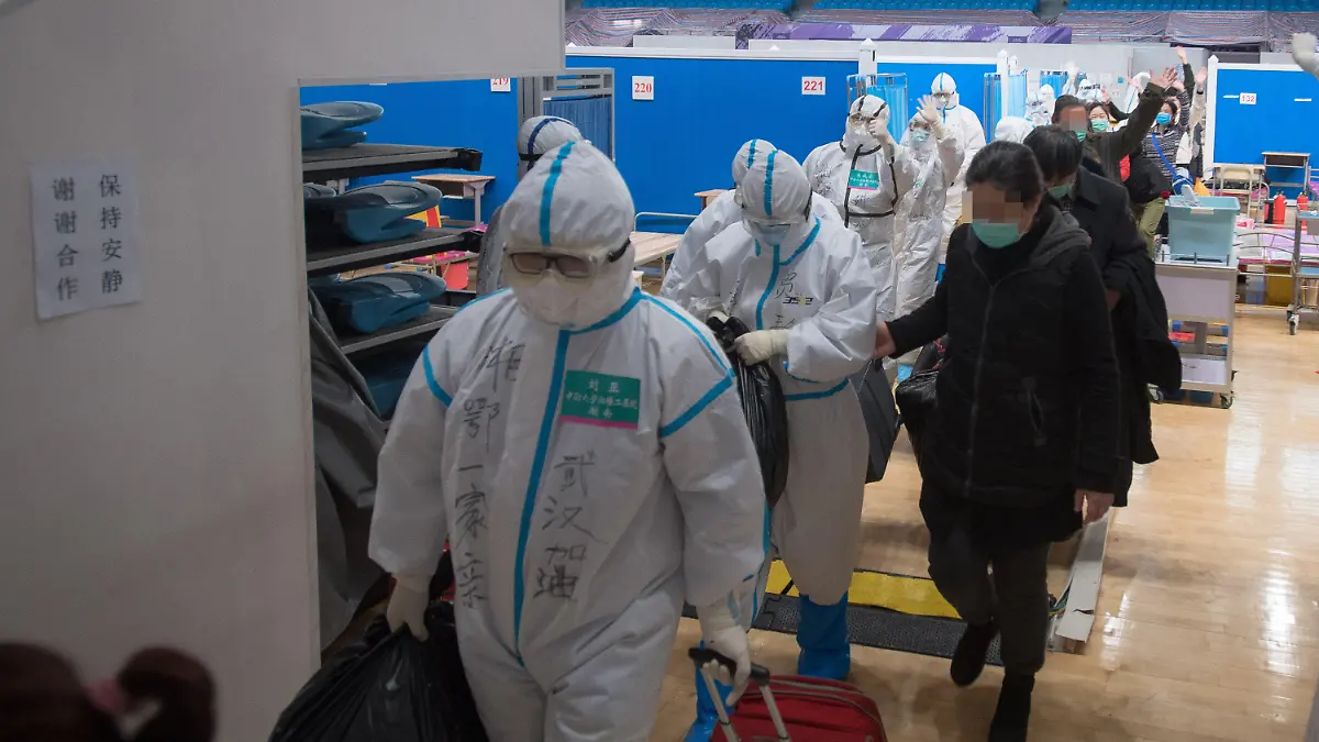 10.03.2020, China, Wuhan: Medizinisches Personal begleitet vom neuartigen Coronavirus geheilte Patienten aus einem provisorischen Krankenhaus. Mit 24 neu nachgewiesenen Fällen ist die Zahl der Coronavirus-Erkrankungen in China wieder leicht gestiegen. Foto: Xiao Yijiu/XinHua/dpa +++ dpa-Bildfunk +++