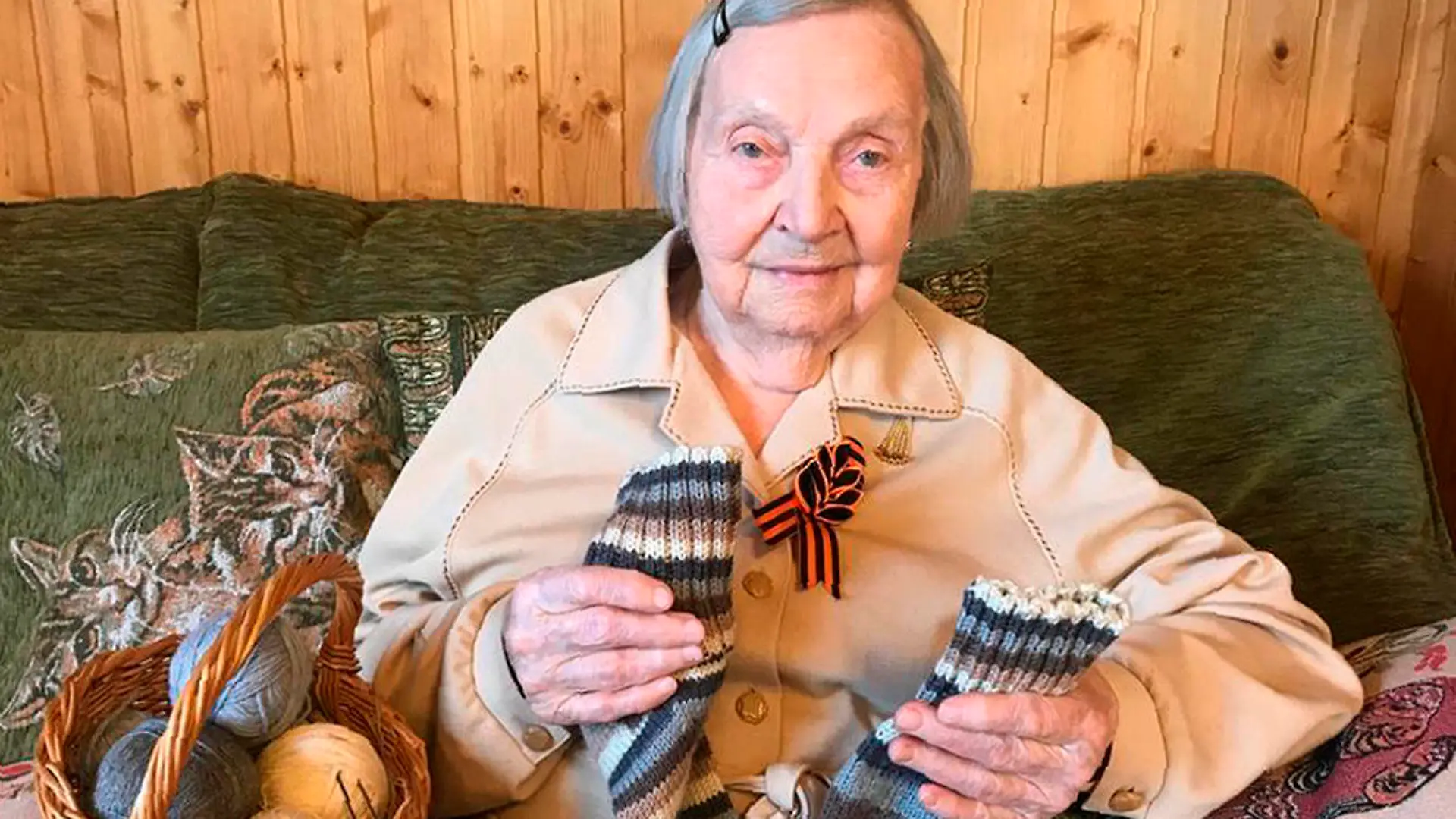 In this family photo taken by Dmitry Panov, Zinaida Korneva, World War II veteran, shows the socks she knitted for Thomas Moore, a British World War II veteran who raised millions of pounds for charity in the run-up to his 100th birthday, during her interview with the Associated Press in St. Petersburg, Russia, Tuesday, May 5, 2020. Inspired by Captain Tom Moore's renowned fund-raising effort amid the coronavirus pandemic, Zinaida Korneva, 97, Russian World War II veteran has launched her own effort to gather contributions for the families of doctors and nurses who have died of the infection. (Dmitry Panov via AP)