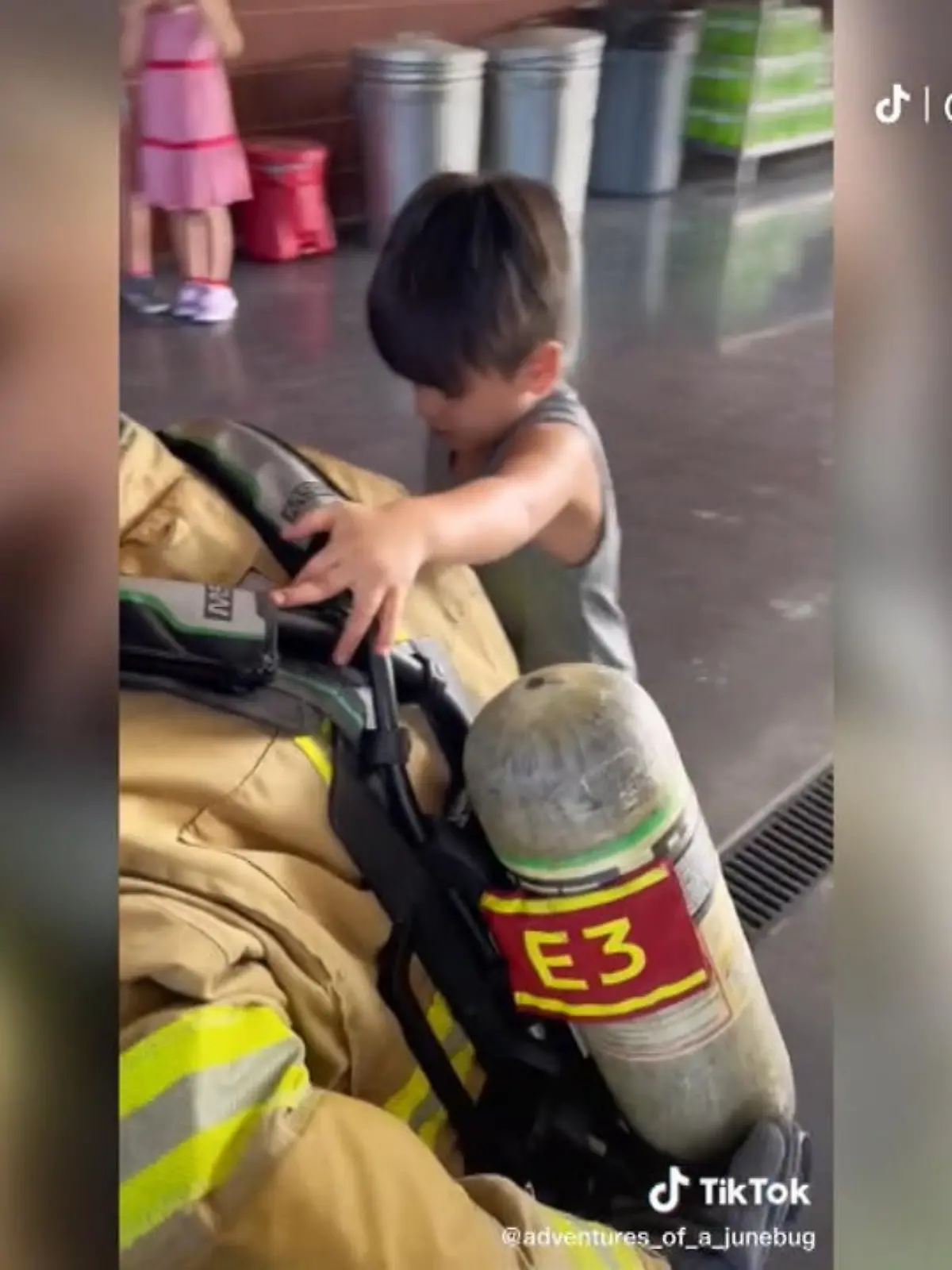 Hier geht der Kleine Junie auf Tuchfühlung mit einem Feuerwehrmann. Bisher hat der blinde Junge nämlich nur in Erzählungen von den heldenhaften Männern gehört, die kommen, wenn es brenzlig wird. Da schaut, beziehungsweise fühlt, er ganz genau hin - denn Junie ist seit einiger Zeit großer Fan, hatte aber bisher nie die Chance, einen echten Feuerwehrmann treffen zu können.