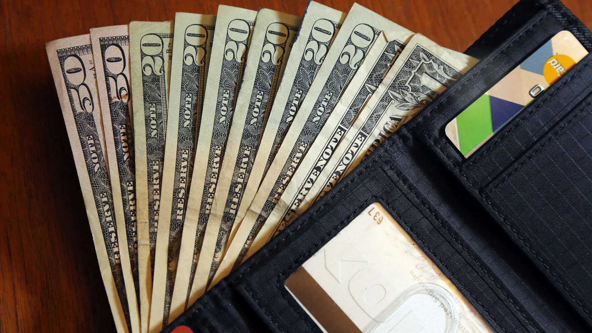 FILE - In this June 15, 2018, file photo, cash is fanned out from a wallet in North Andover, Mass. Using a financial adviser for your investment needs is 100% on brand, but what about all the other parts of your retirement life? A third of people ages 64 and up have a financial adviser, but only 2% asked their adviser to help with their Medicare choices, according to a July 2022 report. (AP Photo/Elise Amendola, File)