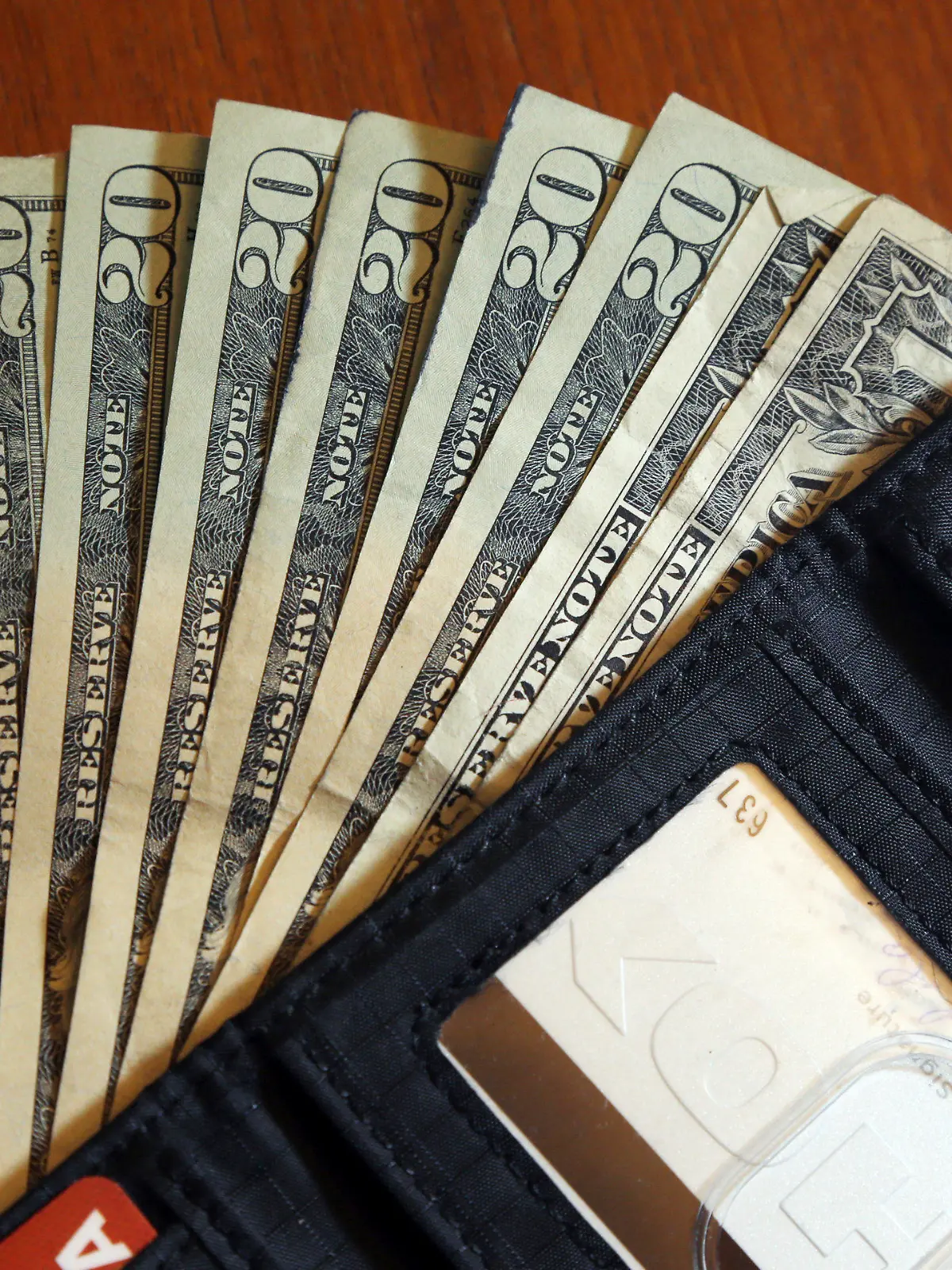 FILE - In this June 15, 2018, file photo, cash is fanned out from a wallet in North Andover, Mass. Using a financial adviser for your investment needs is 100% on brand, but what about all the other parts of your retirement life? A third of people ages 64 and up have a financial adviser, but only 2% asked their adviser to help with their Medicare choices, according to a July 2022 report.  (AP Photo/Elise Amendola, File)
