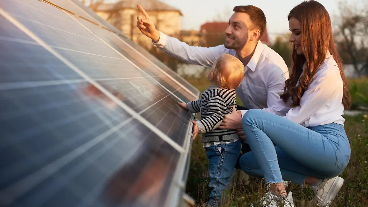 Einer junge, moderne Familie mit einem kleinen Jungen, der Solarpanel kennen lernt