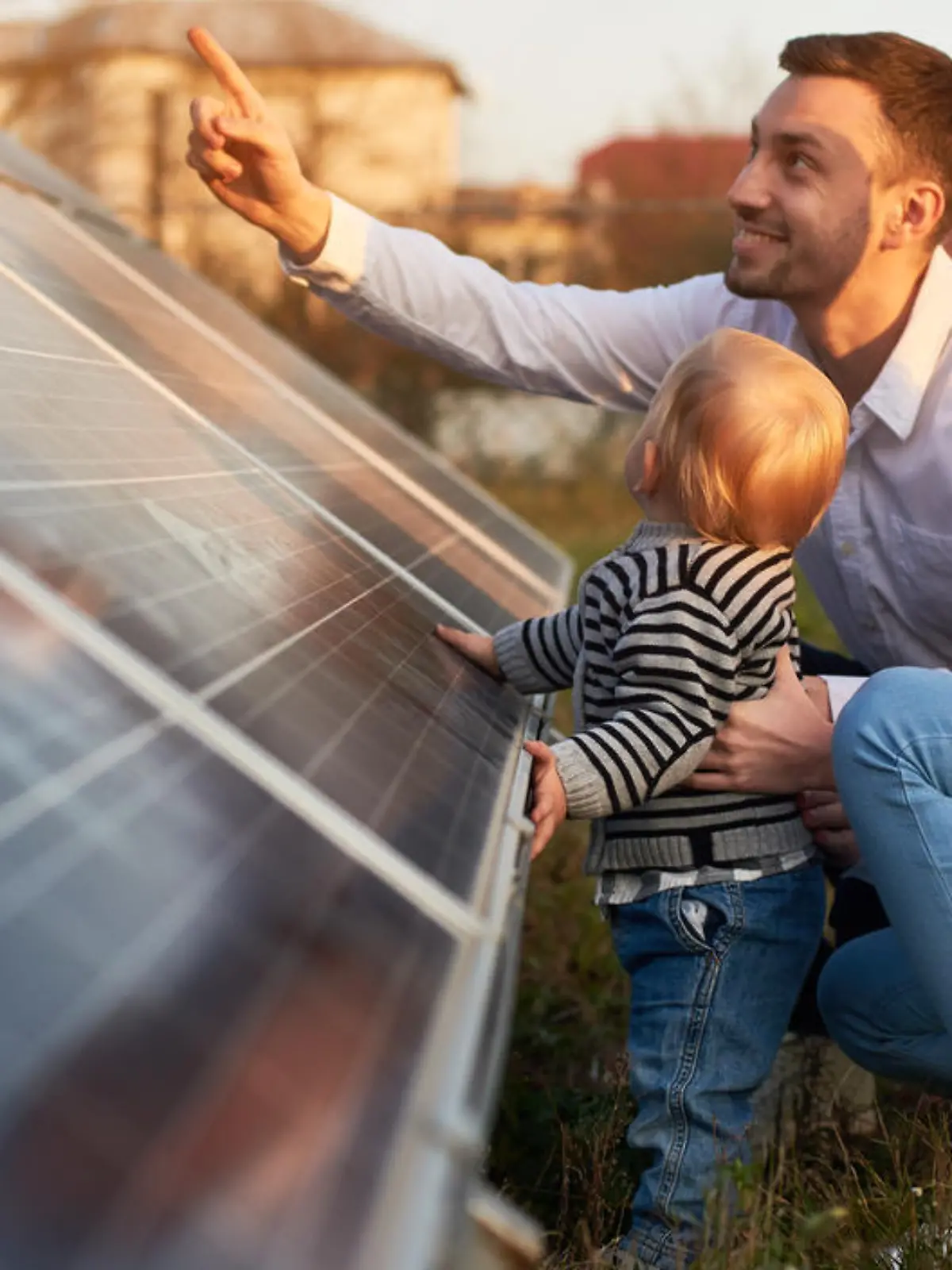 Einer junge, moderne Familie mit einem kleinen Jungen, der Solarpanel kennen lernt