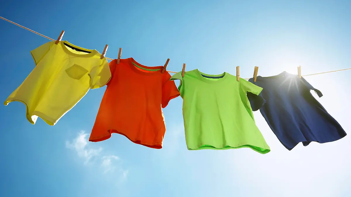 Wäsche, T-shirts hanging on a clothesline in front of blue sky and sun
