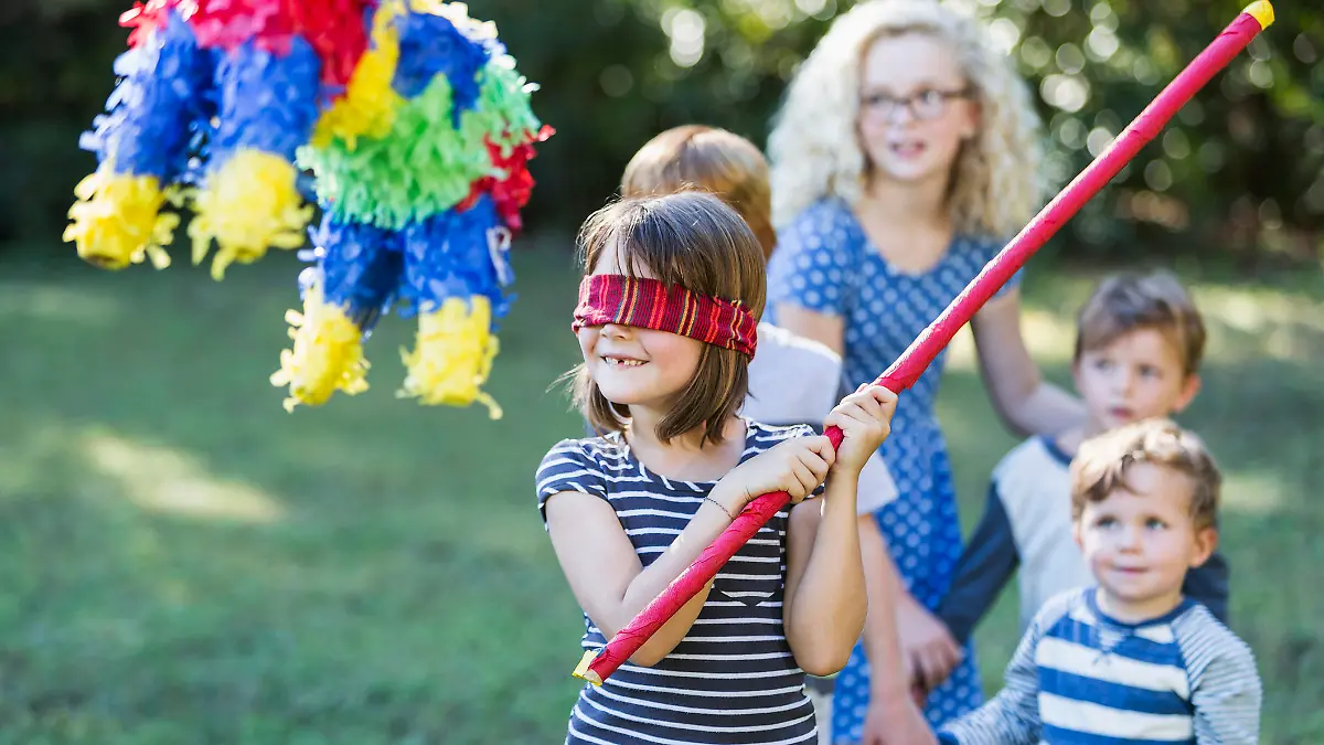 Kindern macht das Zerschlagen einer Piñata viel Spaß