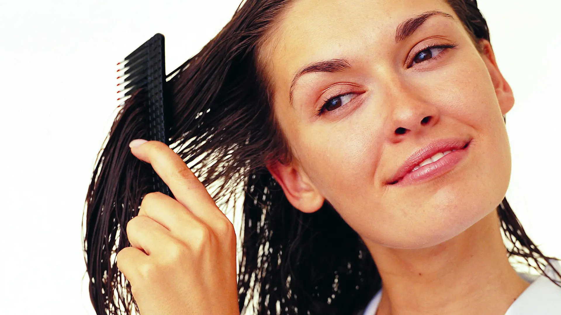 Eine Frau kämmt sich ihre nassen Haare.