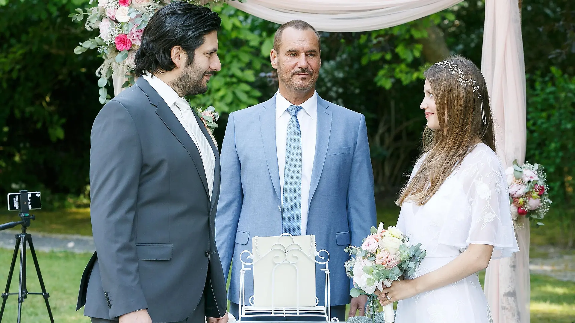 Nathalie (Amrei Haardt) und Maximilian (Francisco Medina) besiegeln ihre Liebe, Richard (Silvan-Pierre Leirich, M.) führt die Trauungszeremonie durch.
Die Verwendung des sendungsbezogenen Materials ist nur mit dem Hinweis und Verlinkung auf TVNOW gestattet.