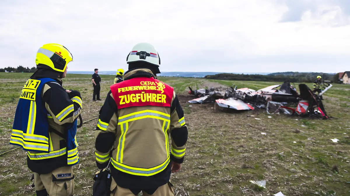24.09.2022, Thüringen, Gera-Leumnitz: Einsatzkräfte der Feuerwehr Gera sind an der Unglücksstelle an der zwei Kunstflieger kollidiert und abgestürzt sind. Bei einem Zusammenstoß von zwei Flugzeugen am Samstagabend am Rande von Gera sind zwei Menschen ums Leben gekommen. Einem Sprecher der Feuerwehr zufolge handelt es sich bei den Verunglückten um zwei Kunstflieger, die mit ihren jeweiligen Maschinen in der Nähe des Flugplatzes Leumnitz am Samstagabend in der Luft zusammengeprallt sind. Foto: Björn Walther/bw.pictures/dpa +++ dpa-Bildfunk +++