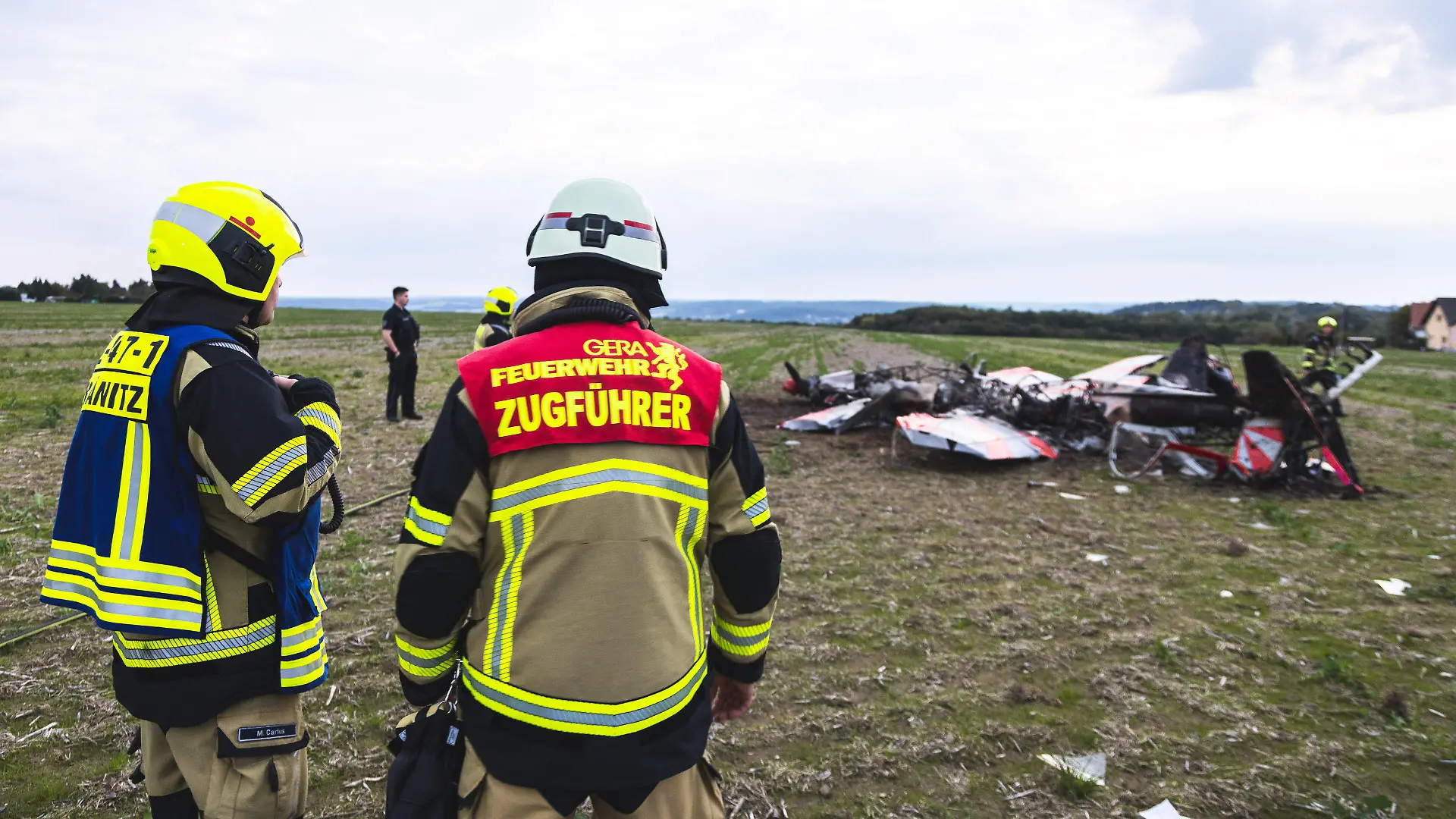 24.09.2022, Thüringen, Gera-Leumnitz: Einsatzkräfte der Feuerwehr Gera sind an der Unglücksstelle an der zwei Kunstflieger kollidiert und abgestürzt sind. Bei einem Zusammenstoß von zwei Flugzeugen am Samstagabend am Rande von Gera sind zwei Menschen ums Leben gekommen. Einem Sprecher der Feuerwehr zufolge handelt es sich bei den Verunglückten um zwei Kunstflieger, die mit ihren jeweiligen Maschinen in der Nähe des Flugplatzes Leumnitz am Samstagabend in der Luft zusammengeprallt sind. Foto: Björn Walther/bw.pictures/dpa +++ dpa-Bildfunk +++