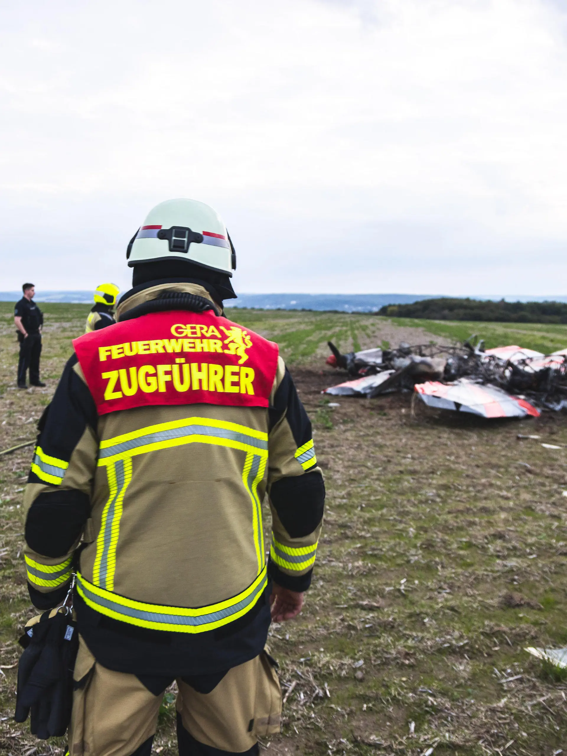 24.09.2022, Thüringen, Gera-Leumnitz: Einsatzkräfte der Feuerwehr Gera sind an der Unglücksstelle an der zwei Kunstflieger kollidiert und abgestürzt sind. Bei einem Zusammenstoß von zwei Flugzeugen am Samstagabend am Rande von Gera sind zwei Menschen ums Leben gekommen. Einem Sprecher der Feuerwehr zufolge handelt es sich bei den Verunglückten um zwei Kunstflieger, die mit ihren jeweiligen Maschinen in der Nähe des Flugplatzes Leumnitz am Samstagabend in der Luft zusammengeprallt sind. Foto: Björn Walther/bw.pictures/dpa +++ dpa-Bildfunk +++