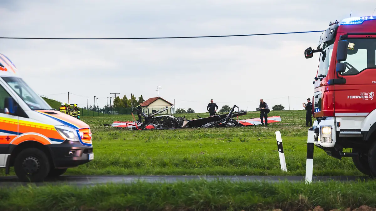 24.09.2022, Thüringen, Gera-Leumnitz: Einsatzkräfte der Polizei und Feuerwehr sind an der Unglücksstelle an der zwei Flugzeuge kollidiert und abgestürzt sind. Bei einem Zusammenstoß von zwei Flugzeugen am Samstagabend am Rande von Gera sind zwei Menschen ums Leben gekommen. Einem Sprecher der Feuerwehr zufolge handelt es sich bei den Verunglückten um zwei Kunstflieger, die mit ihren jeweiligen Maschinen in der Nähe des Flugplatzes Leumnitz am Samstagabend in der Luft zusammengeprallt sind. Foto: Björn Walther/bw.pictures/dpa +++ dpa-Bildfunk +++