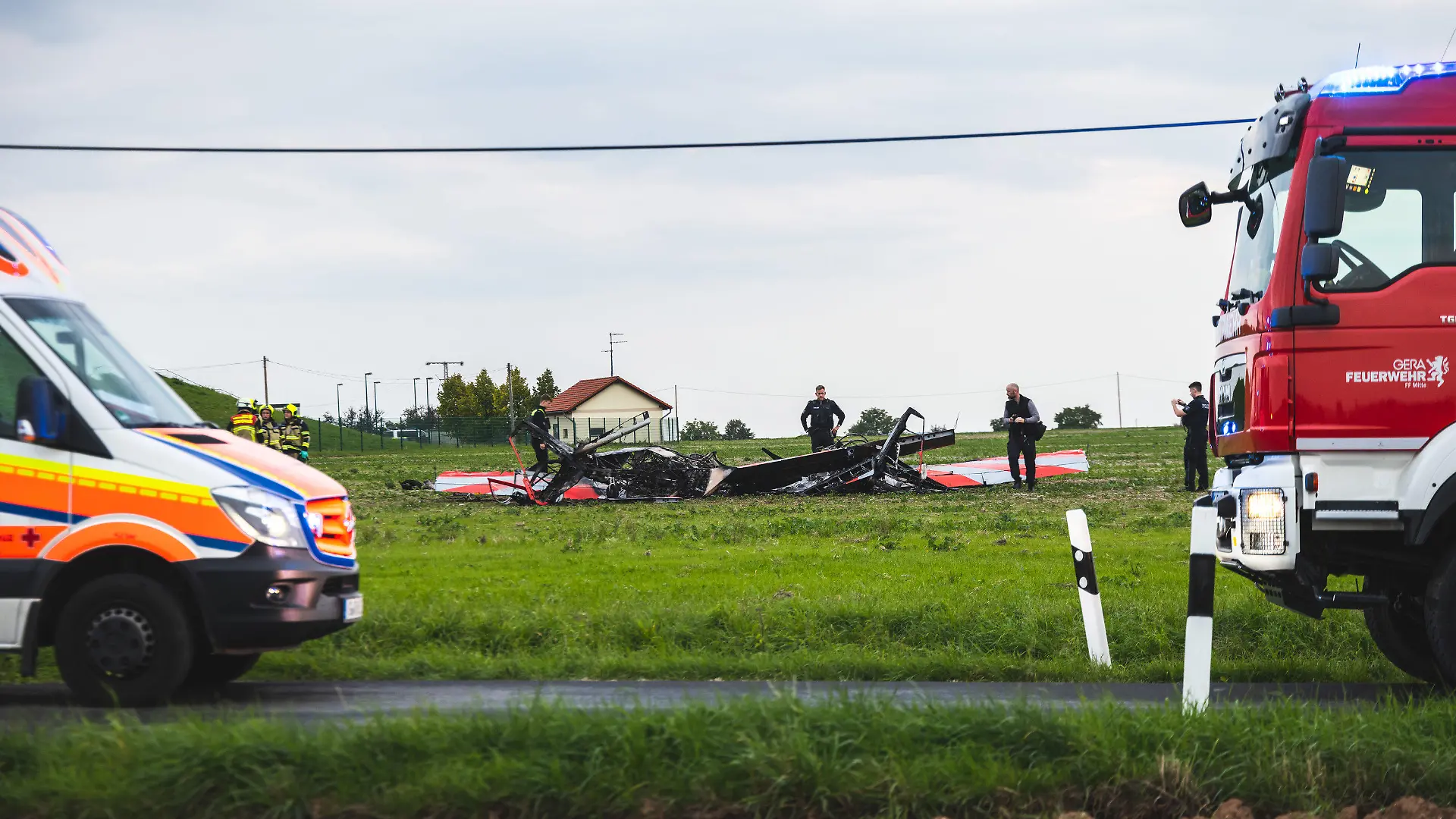 24.09.2022, Thüringen, Gera-Leumnitz: Einsatzkräfte der Polizei und Feuerwehr sind an der Unglücksstelle an der zwei Flugzeuge kollidiert und abgestürzt sind. Bei einem Zusammenstoß von zwei Flugzeugen am Samstagabend am Rande von Gera sind zwei Menschen ums Leben gekommen. Einem Sprecher der Feuerwehr zufolge handelt es sich bei den Verunglückten um zwei Kunstflieger, die mit ihren jeweiligen Maschinen in der Nähe des Flugplatzes Leumnitz am Samstagabend in der Luft zusammengeprallt sind. Foto: Björn Walther/bw.pictures/dpa +++ dpa-Bildfunk +++
