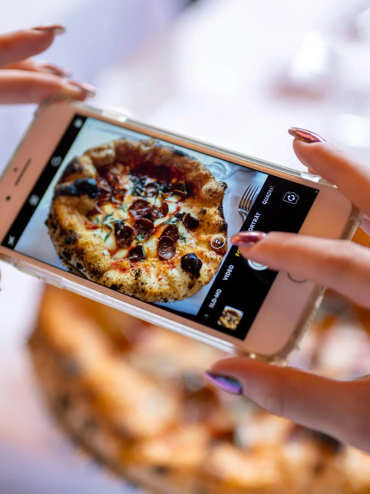 19.08.2022, Berlin: Eine Frau fotografiert mit ihrem Smartphone das Gericht «Drop it like it's hot» im Restaurant «Coccodrillo» im Weinbergspark. Hauptsache «instagrammable» scheint das Motto mancher neuer Lokale zu sein. (zu dpa-Korr «Überwältigend»: Wie die Instagramisierung der Gastrowelt weitergeht») Foto: Monika Skolimowska/dpa +++ dpa-Bildfunk +++