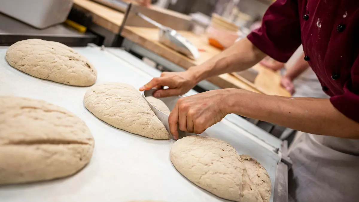 Eine Person arbeitet in der Bäcker-Innung Berlin an einem Brot.