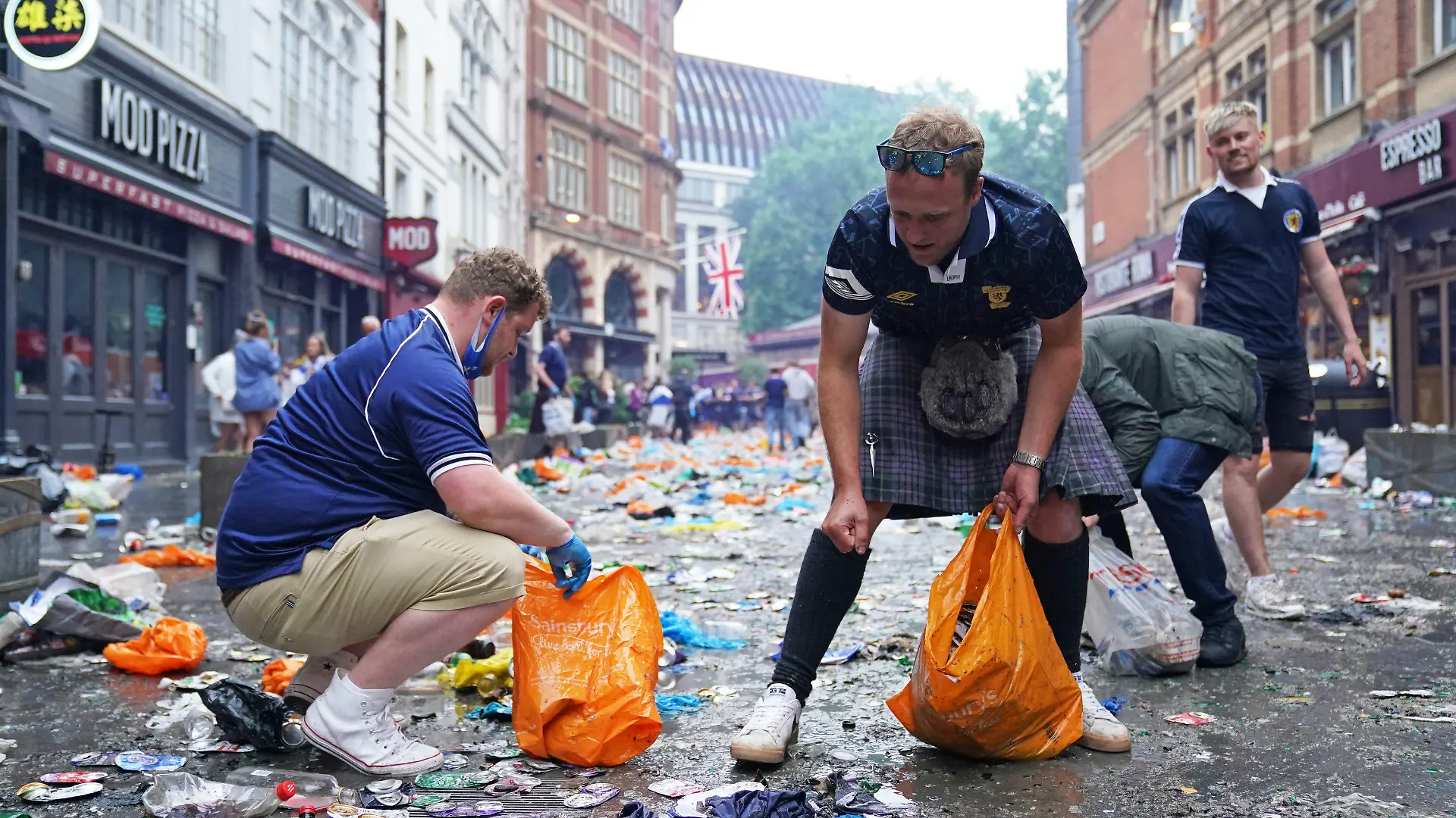 18.06.2021, Großbritannien, London: Fußball: EM, England - Schottland, Vorrunde, Gruppe D, 2. Spieltag, vor dem Spiel: Schottische Fans sammeln Müll und räumen in der Irving Street auf. Foto: Kirsty O'connor/PA Wire/dpa +++ dpa-Bildfunk +++