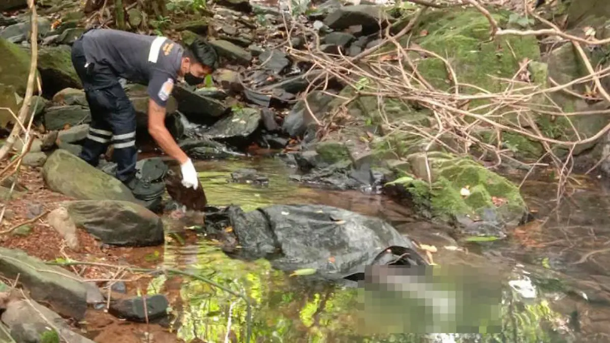 EDS NOTE: GRAPHIC CONTENT - An officer inspects the scene where a woman was found dead at a secluded spot on the southern island of Phuket, Thailand, on Thursday, Aug. 5, 2021. Thai media, quoting police, said the woman was a 57-year-old Swiss national. (AP Photo)