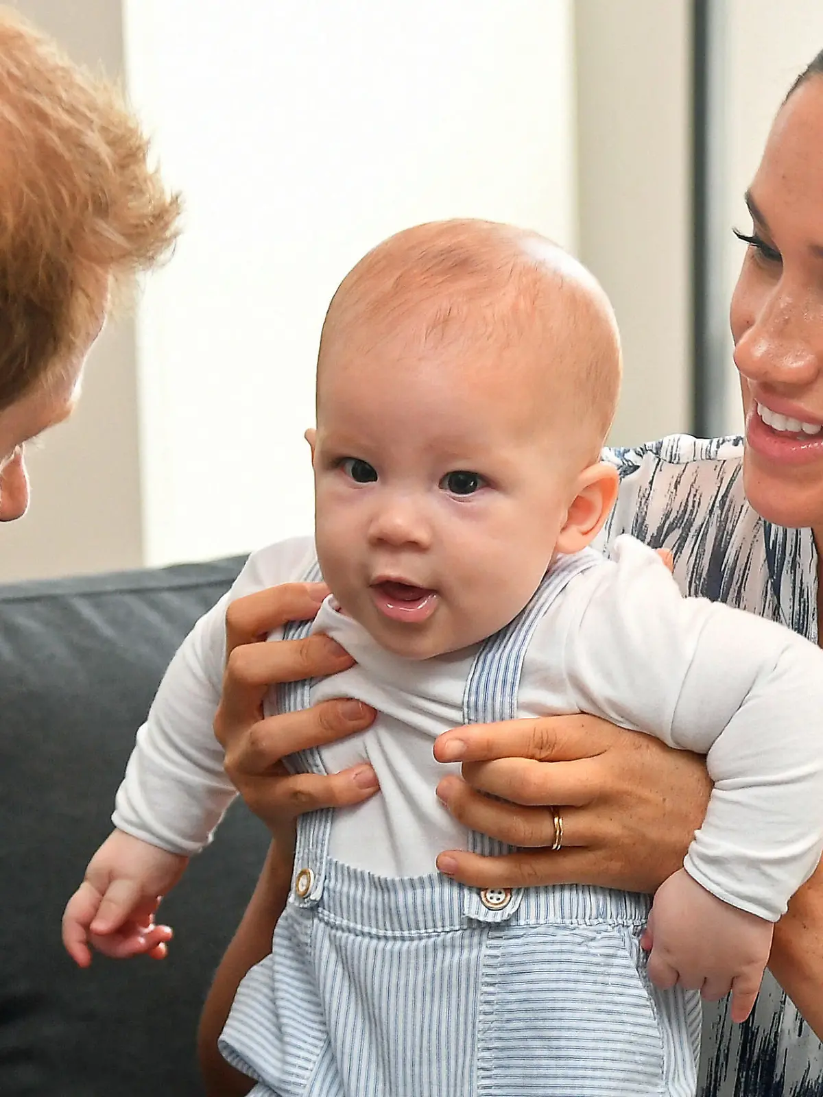 ARCHIV - 29.09.2019, Südafrika, Kapstadt: Der britische Prinz Harry (l), Herzog von Sussex, und seine Frau Meghan, Herzogin von Sussex, mit Sohn Archie während eines Treffens mit Erzbischof Desmond Tutu in ihrer Legacy Foundation am dritten Tag ihrer Afrika-Reise. Zum zweiten Geburtstag ihres Sohnes Archie haben Prinz Harry (36) und Herzogin Meghan (39) zu Spenden für Corona-Impfungen in ärmeren Ländern aufgerufen. Foto: Toby Melville/PA Wire/dpa +++ dpa-Bildfunk +++