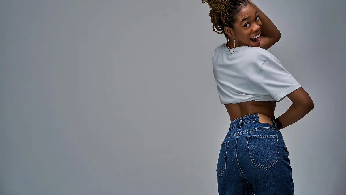Lady smiling showing her back in a t-shirt and ass in jeans with pockets