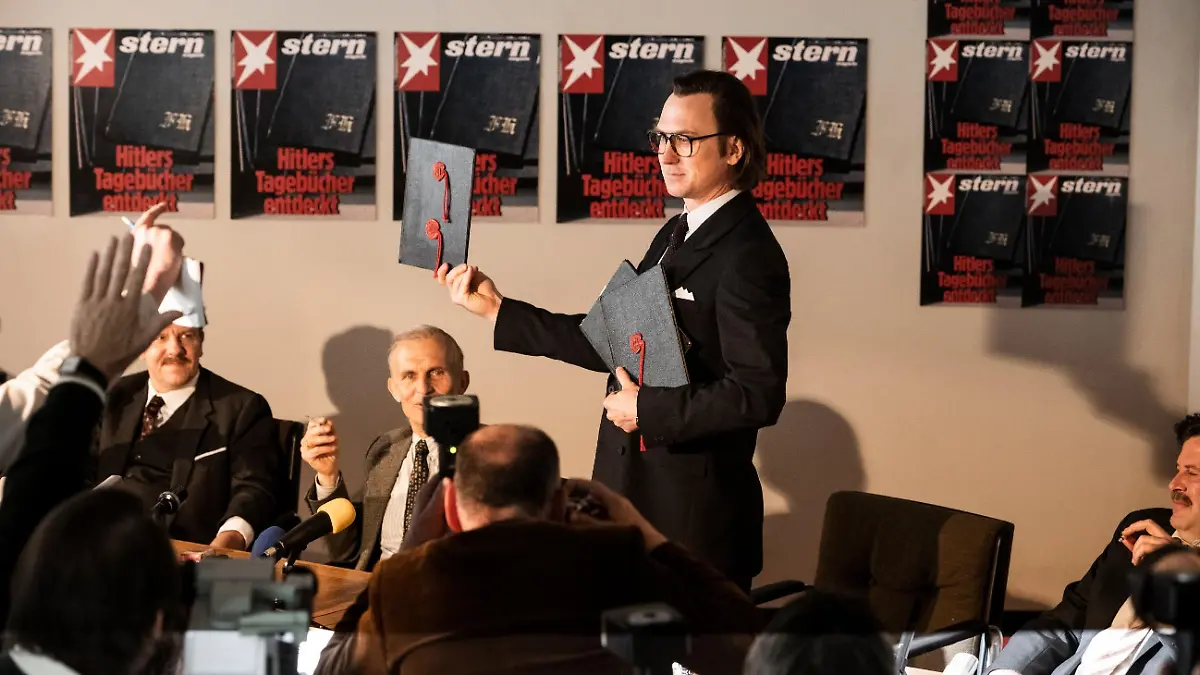 Pressekonferenz in der Stern Redaktion: Gerd Heidemann (Lars Eidinger) präsentiert die Hitler Tagebücher und liest aus ihnen vor.
Die Verwendung des sendungsbezogenen Materials ist nur mit dem Hinweis und Verlinkung auf TVNOW gestattet.