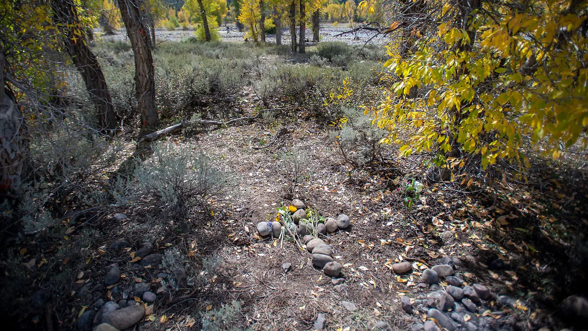 A stone cross marks a spot in northwest Wyoming's Bridger-Teton National Forest, Thursday, Sept. 23, 2021, where the remains of Gabrielle "Gabby" Petito were discovered on Sept. 19 near Spread Creek. Gary Rider, a friend of Petito's stepfather, James Schmidt, told The Independent they visited the site on Sept. 22 and created the memorial. Rider also said that a larger cross about 50 yards away and closer to the river, "was not done by anyone connected with the search or recovery of Gabby." (Bradley J. Boner/Jackson Hole News & Guide via AP)
