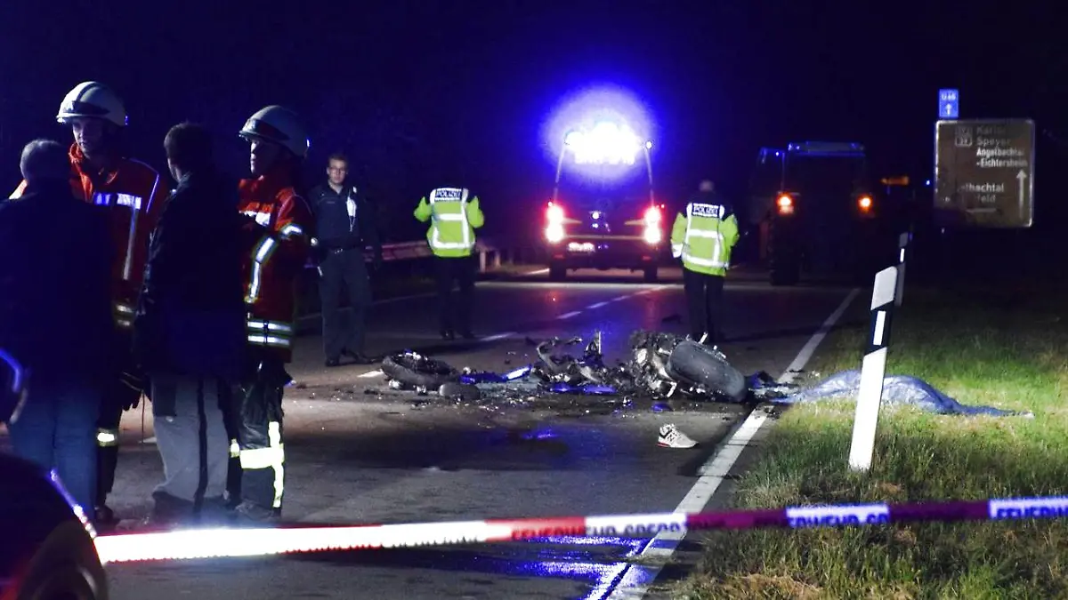 25.10.2021, Baden-Württemberg, Dühren: Polizisten und Feuerwehrmänner stehen neben einem vollkommen zerstörten Motorrad auf der B292. Die Bundesstraße ist am Montagabend nach dem schweren Unfall am Ortseingang in beide Richtungen gesperrt worden. Es habe einen schweren Unfall mit einem Traktor und einem Motorrad gegeben, teilte das Polizeipräsidium Mannheim mit. Foto: Julian Buchner/dpa +++ dpa-Bildfunk +++