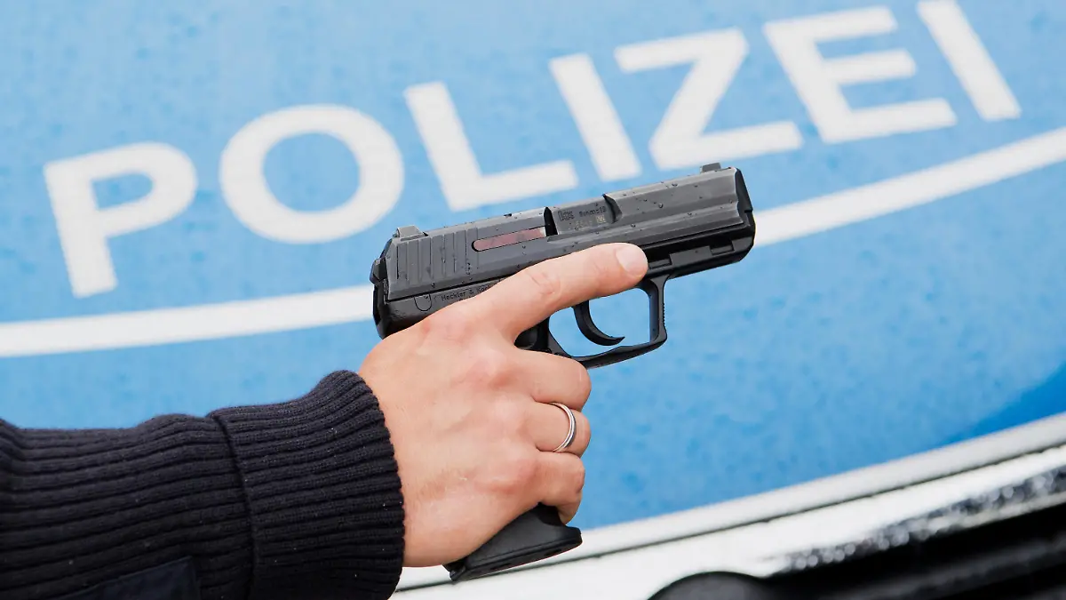ARCHIV - 13.06.2016, Niedersachsen, Hannover: Ein Polizist posiert für Fotoaufnahmen mit seiner Dienstwaffe HK P2000 9mm vor einem Polizeifahrzeug. (zu dpa "Polizisten machen nur selten von der Waffe Gebrauch" vom 22.07.2018) Foto: Julian Stratenschulte/dpa +++ dpa-Bildfunk +++