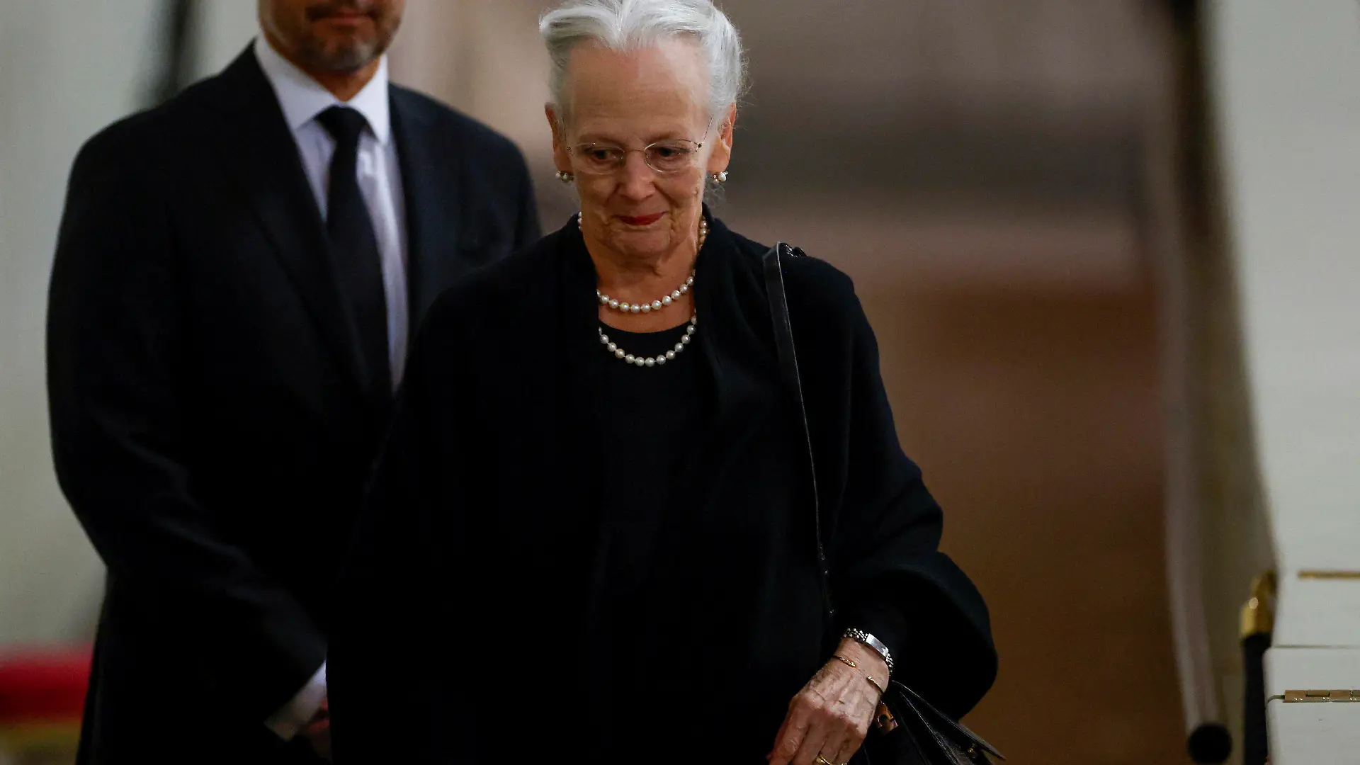 ARCHIV - 18.09.2022, Großbritannien, London: Die dänische Königin Margrethe erweist dem Sarg der britischen Königin Elizabeth nach ihrem Tod während ihrer Aufbahrung in der Westminster Hall die letzte Ehre. Dahinter steht Kronprinz Frederik von Dänemark. Die dänische Königin Margrethe II. (82) ist nach ihrer Teilnahme an der Trauerfeier für die britische Queen positiv auf das Coronavirus getestet worden. Foto: John Sibley/Reuters Pool/AP/dpa +++ dpa-Bildfunk +++