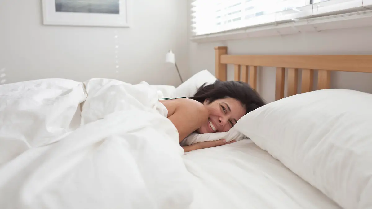Smiling Hispanic woman laying in bed, Smiling Hispanic Frau im Bett || Modellfreigabe vorhanden