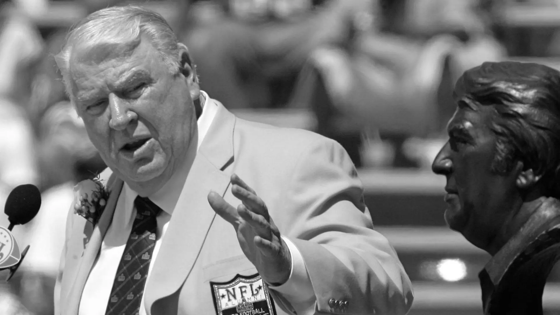 ARCHIV - 05.08.2006, USA, Canton: John Madden, ehemaliger Trainer der Oakland Raiders, gestikuliert während seiner Aufnahme in die Pro Football Hall of Fame in Canton, Ohio, in Richtung einer Büste von ihm. Die Football-Welt trauert um John Madden. Die Trainer- und Kommentatorenlegende ist am Dienstag, 28.12.2021, im Alter von 85 Jahren gestorben. Foto: Mark Duncan/AP/dpa +++ dpa-Bildfunk +++