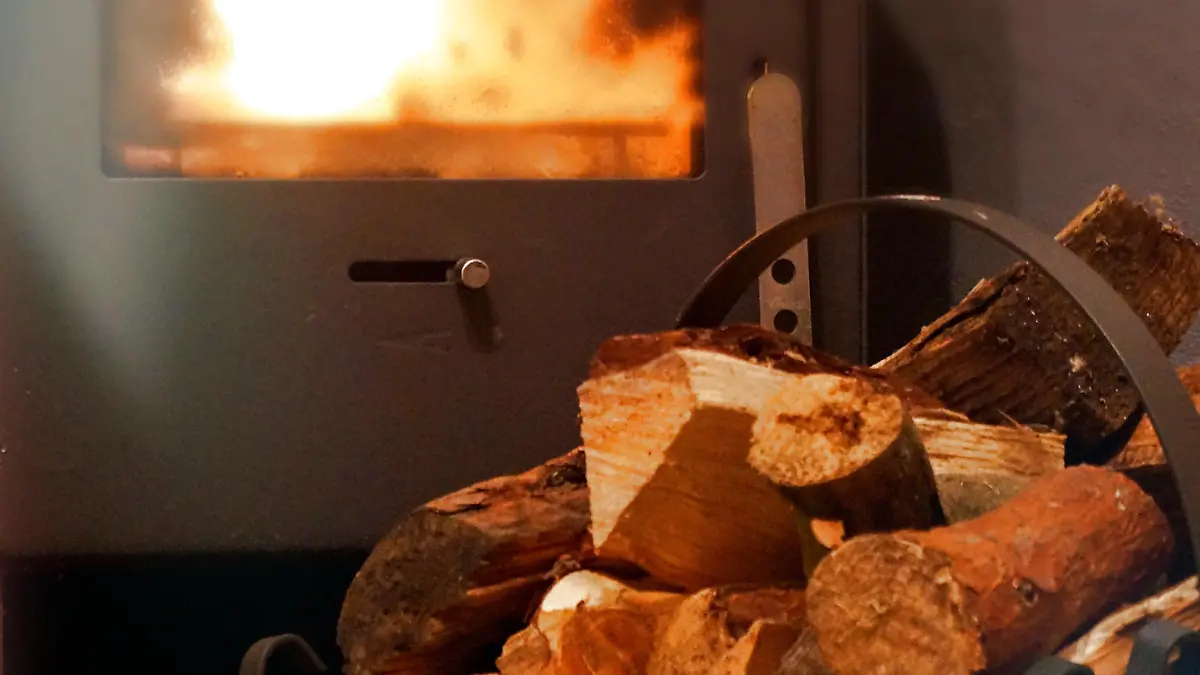 Logs of wood in a basket in front of the fireplace