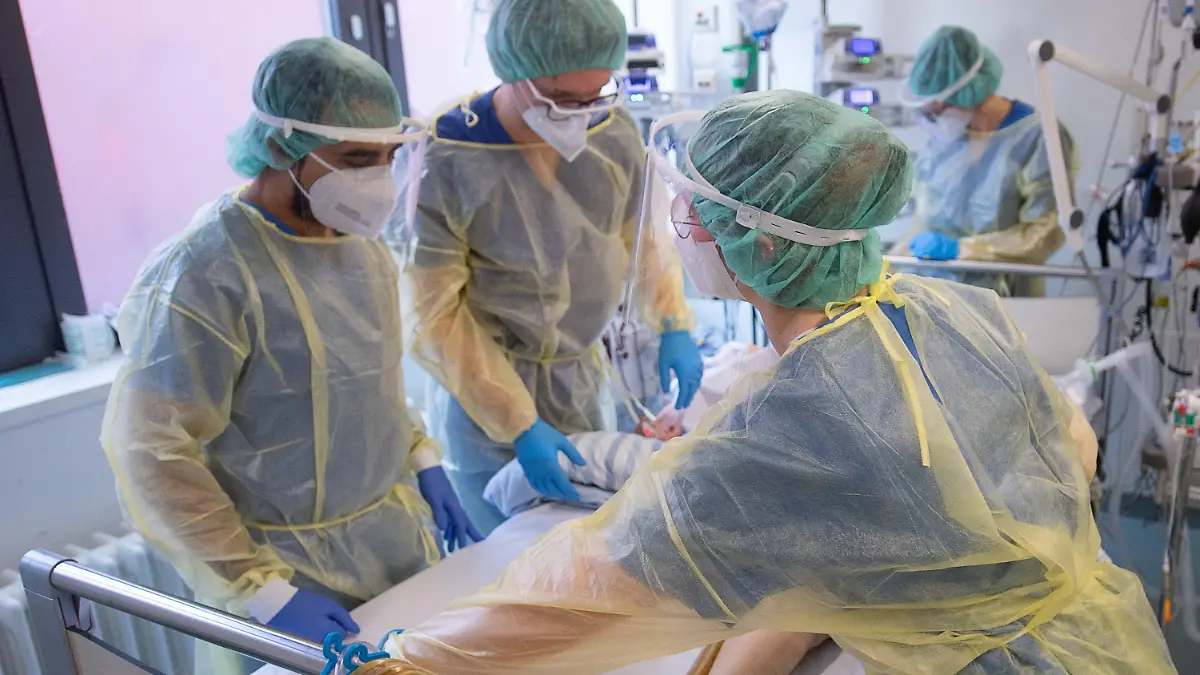 05.01.2022, Hessen, Offenbach am Main: Pfleger und Pflegerinnen sowie eine Ärztin kümmern sich auf der Intensivstation für Corona-Patienten am Sana Klinikum Offenbach um einen Patienten. Auf der Corona-Intensivstation sind momentan alle Betten bis auf zwei belegt. Die Coronainfektionszahlen im Rhein-Main-Gebiet steigen jedoch wieder an. Foto: Sebastian Gollnow/dpa +++ dpa-Bildfunk +++