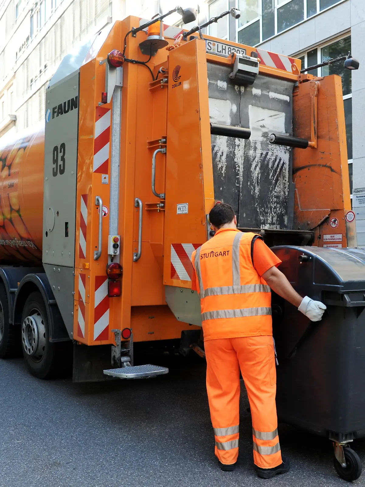 Mitarbeiter der Abfallwirtschaft Stuttgart beladen in der baden-württembergischen Landeshauptstadt Stuttgart einen Müllwagen (Foto vom 23.07.2012). 20 Tonnen Müll entsorgt ein Dreier-Team pro Tag. Foto: Bernd Weißbrod dpa/lsw