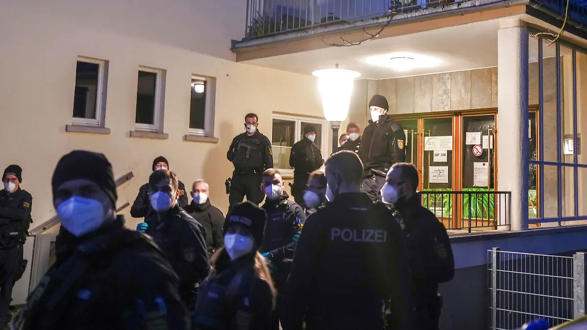Police officers stay in front of the crime scene on the grounds of the Heidelberg University in Heidelberg, Germany, Monday, Jan. 24, 2022. German police say a lone gunman wounded several people at a lecture theatre in the southwest city of Heidelberg on Monday. Police said in a brief statement that the perpetrator was dead but didn't give details of how that happened. (AP Photo/Michael Probst)