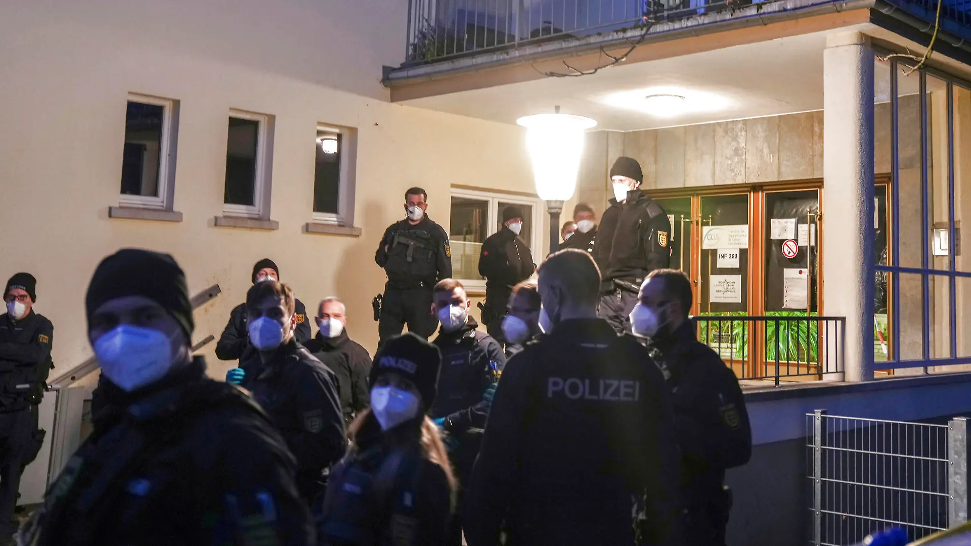 Police officers stay in front of the crime scene on the grounds of the Heidelberg University in Heidelberg, Germany, Monday, Jan. 24, 2022. German police say a lone gunman wounded several people at a lecture theatre in the southwest city of Heidelberg on Monday. Police said in a brief statement that the perpetrator was dead but didn't give details of how that happened. (AP Photo/Michael Probst)