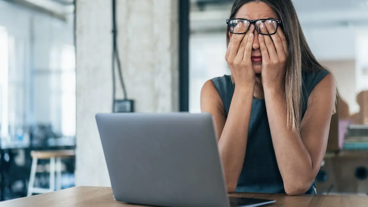 Business woman with hands on her face looking exhausted