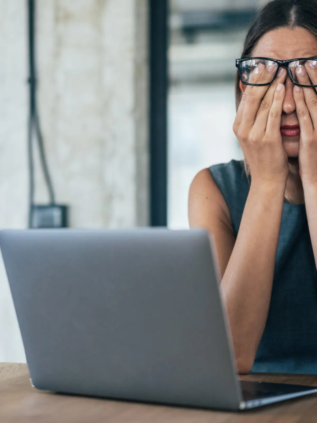Business woman with hands on her face looking exhausted