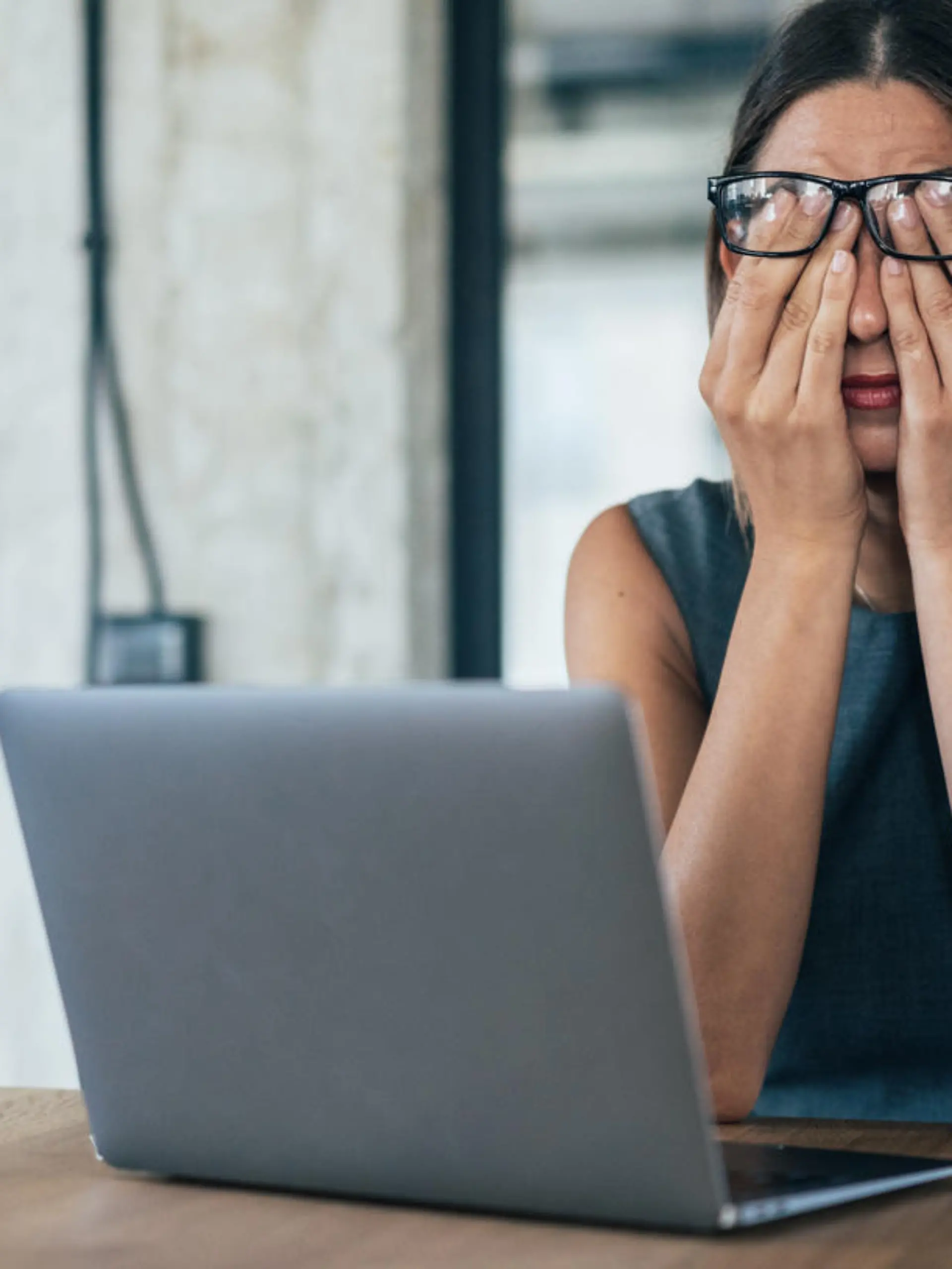 Business woman with hands on her face looking exhausted