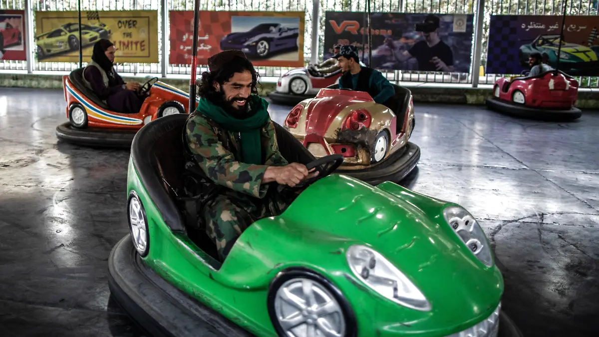 A Taliban fighter drives a bumper car in an amusement park in Kabul.