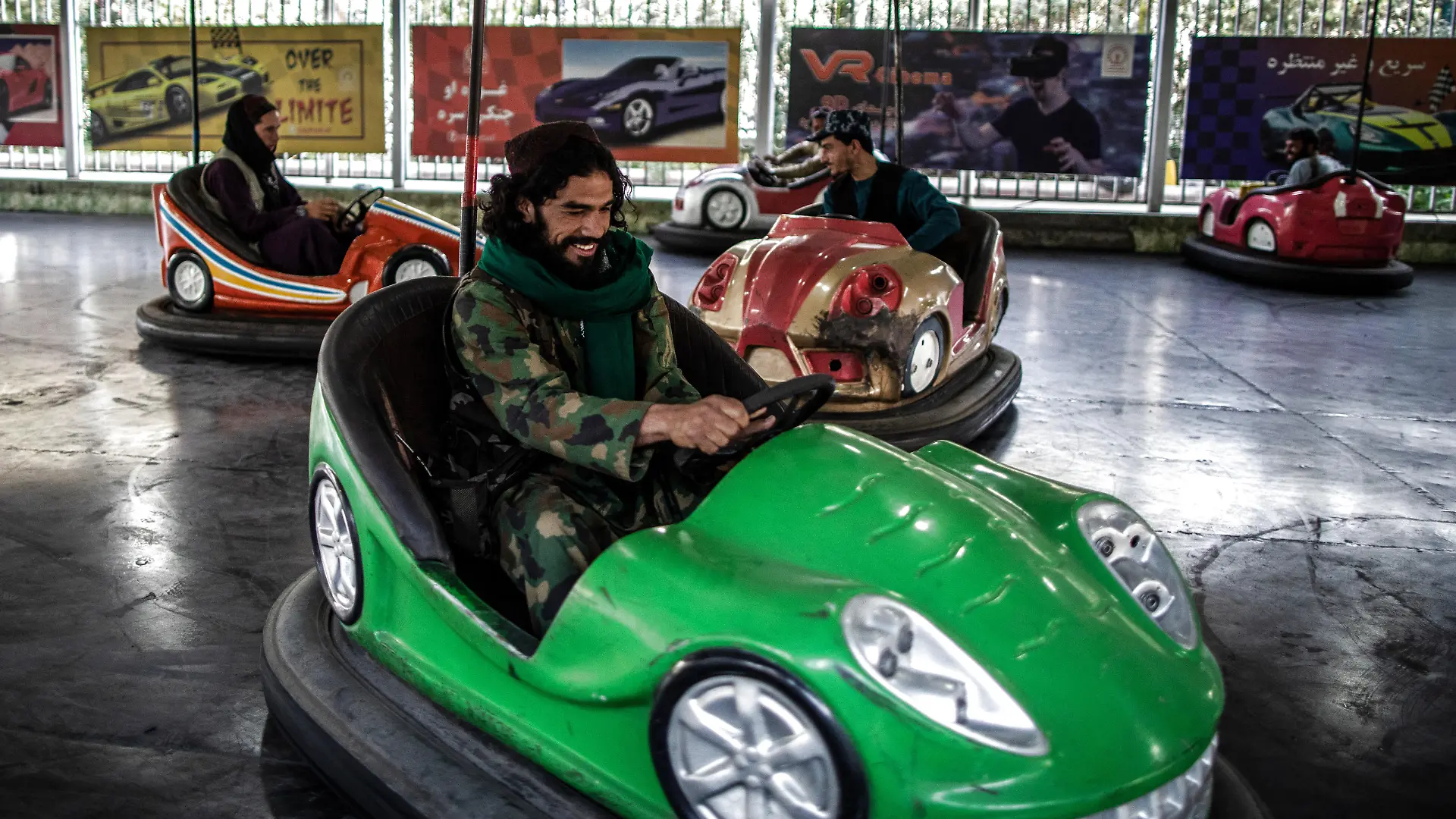A Taliban fighter drives a bumper car in an amusement park in Kabul.