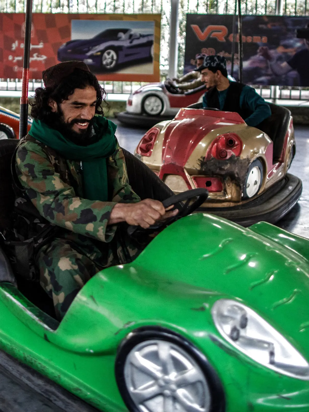A Taliban fighter drives a bumper car in an amusement park in Kabul.
