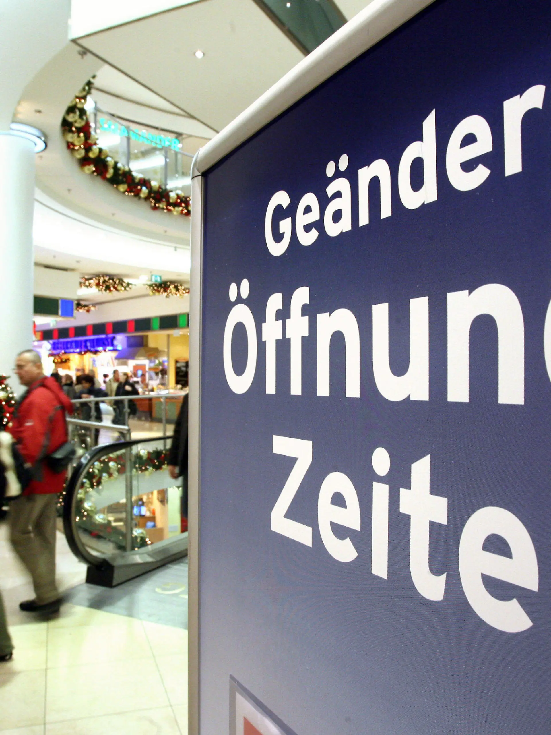 ARCHIV - Auf einem Plakat wird im Einkaufszentrum in Erfurt auf die veränderten Ladenöffnungszeiten hingewiesen, aufgenommen am 30.11.2006. Am Mittwoch (18.01.2012) findet in Düsseldorf eine Expertenanhörung im Wirtschaftsausschuss des Landtags zur Evaluierung des Ladenöffnungs-Gesetzes statt. Foto: Martin Schutt/lnw  +++(c) dpa - Bildfunk+++