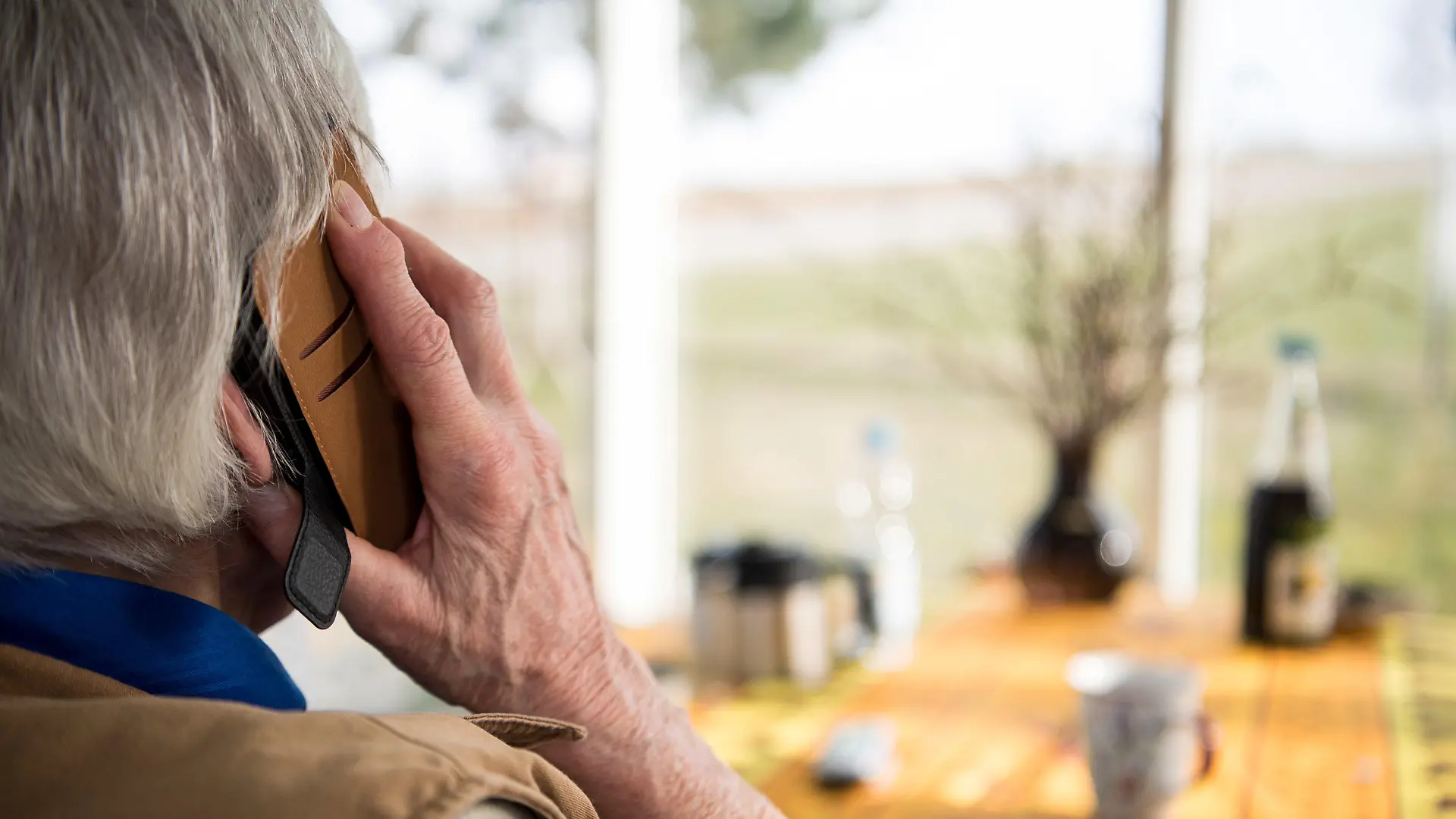 ILLUSTRATION - 06.03.2018, Baden-Württemberg, Mühlacker: Eine Seniorin telefoniert mit ihrem Smartphone. (zu dpa: «Betrüger erbeuten wertvolle Goldmünzen von Seniorin») Foto: Sebastian Gollnow/dpa +++ dpa-Bildfunk +++