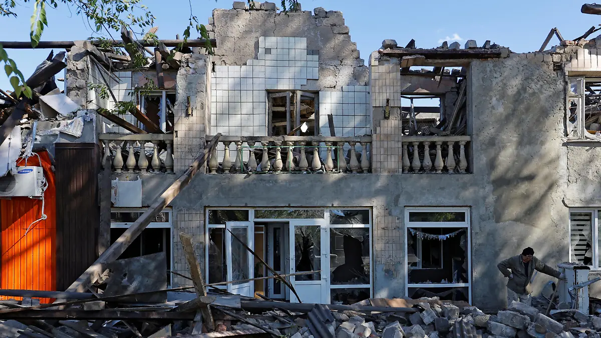 A man removes debris of a building destroyed by recent shelling during Russia-Ukraine conflict in the city of Kadiivka (Stakhanov) in the Luhansk region, Ukraine September 19, 2022. REUTERS/Alexander Ermochenko